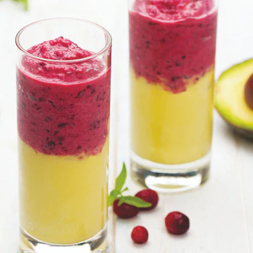 cashew cranberry smoothie layered on top of avocado pineapple smoothie