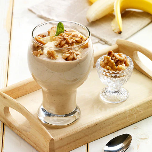 banana protein smoothie in glass with walnuts