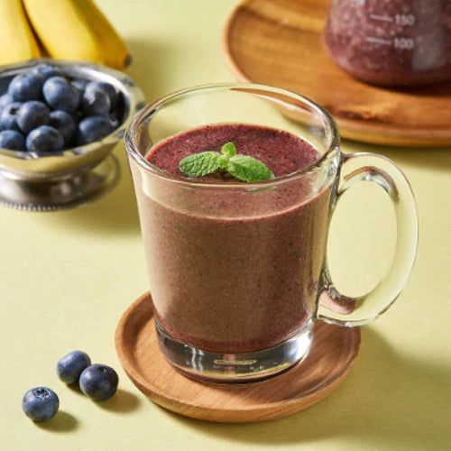 blueberry smoothie in glass cup with handle