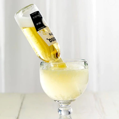 glass of an alcoholic beverage with a corona beer bottle tipped upside down