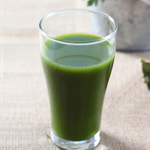 green spinach juice in a glass cup