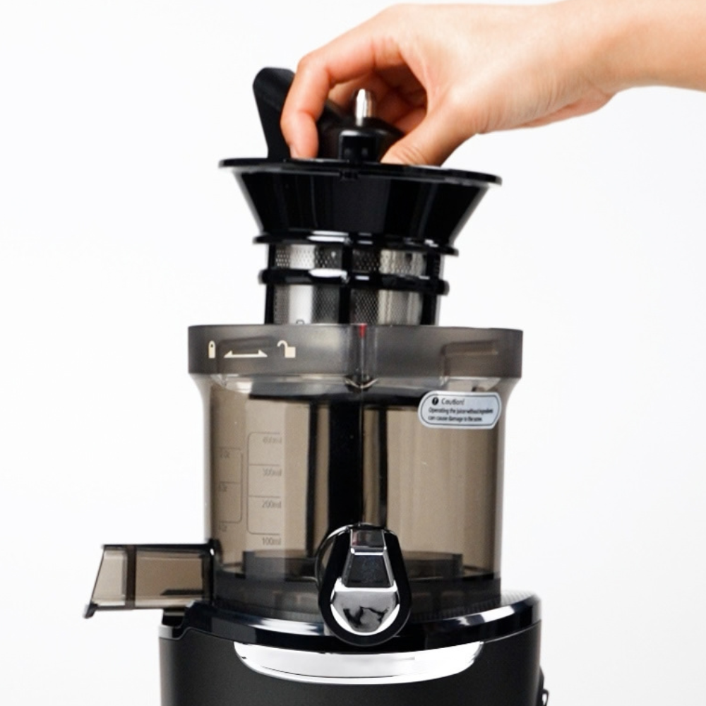 A hand assembling the AUTO9 Juicer