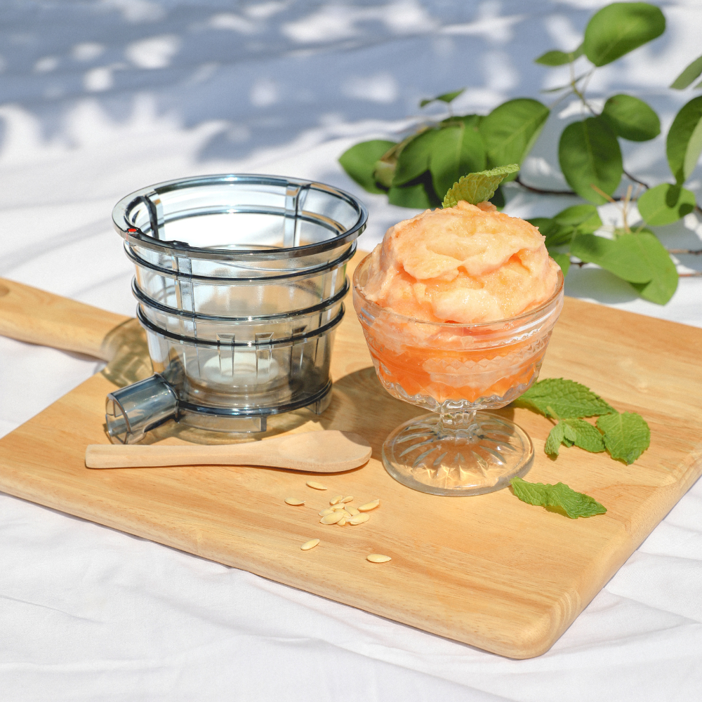 Cantaloupe sorbet and a sorbet strainer on a cutting board