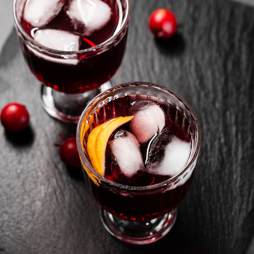 top view of 2 glasses with cherry juice, lemon, and ice in them