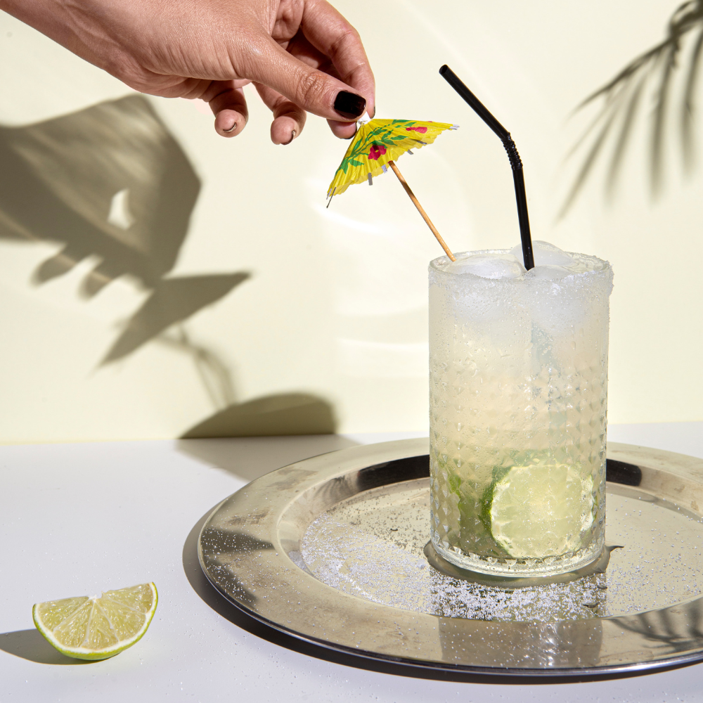 Caipirinha cocktail with straw and umbrella on tray image