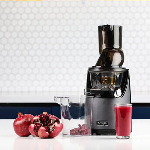 EVO820 juicer and a glass of pomegranate juice on a counter