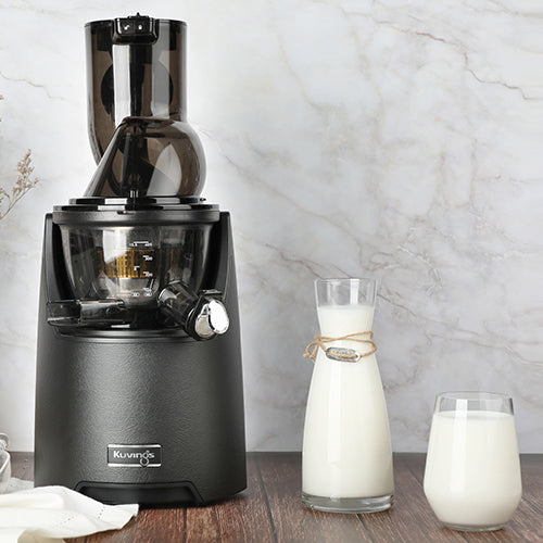white Oat Milk in glass bottle and cup with black jucier