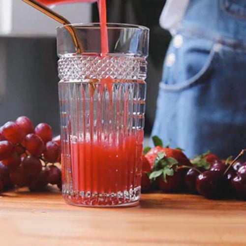 red juice is pouring in glass cup