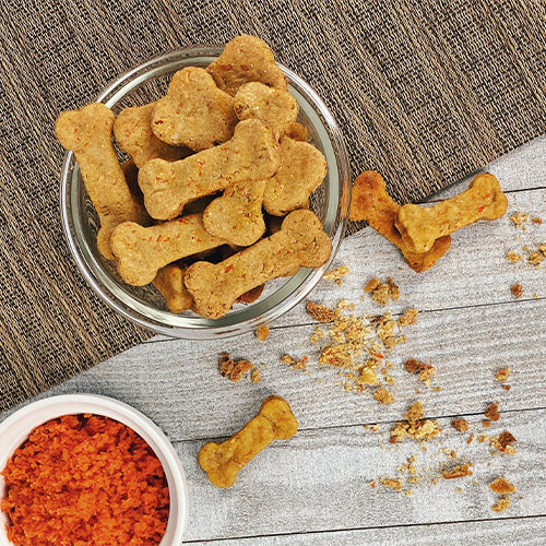 Boned-shaped dog treats in a glass bowl.