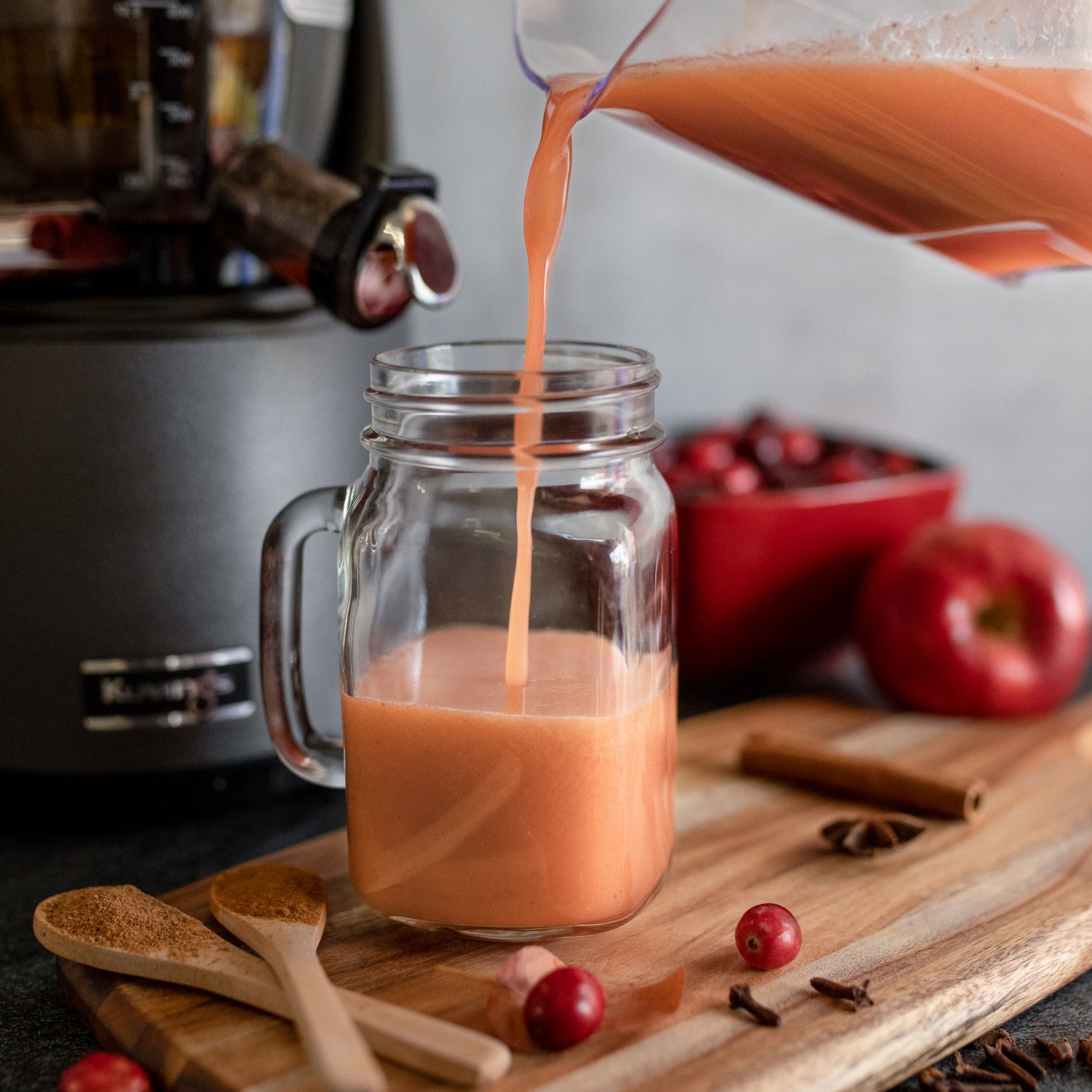 apple cranberry cider pouring into mason jar