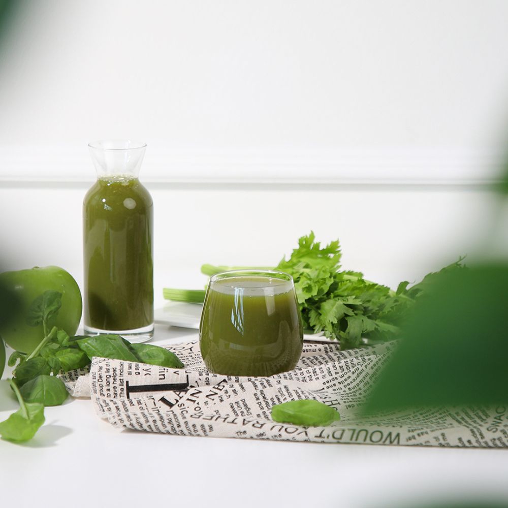 Two glasses of green juice and green ingredients