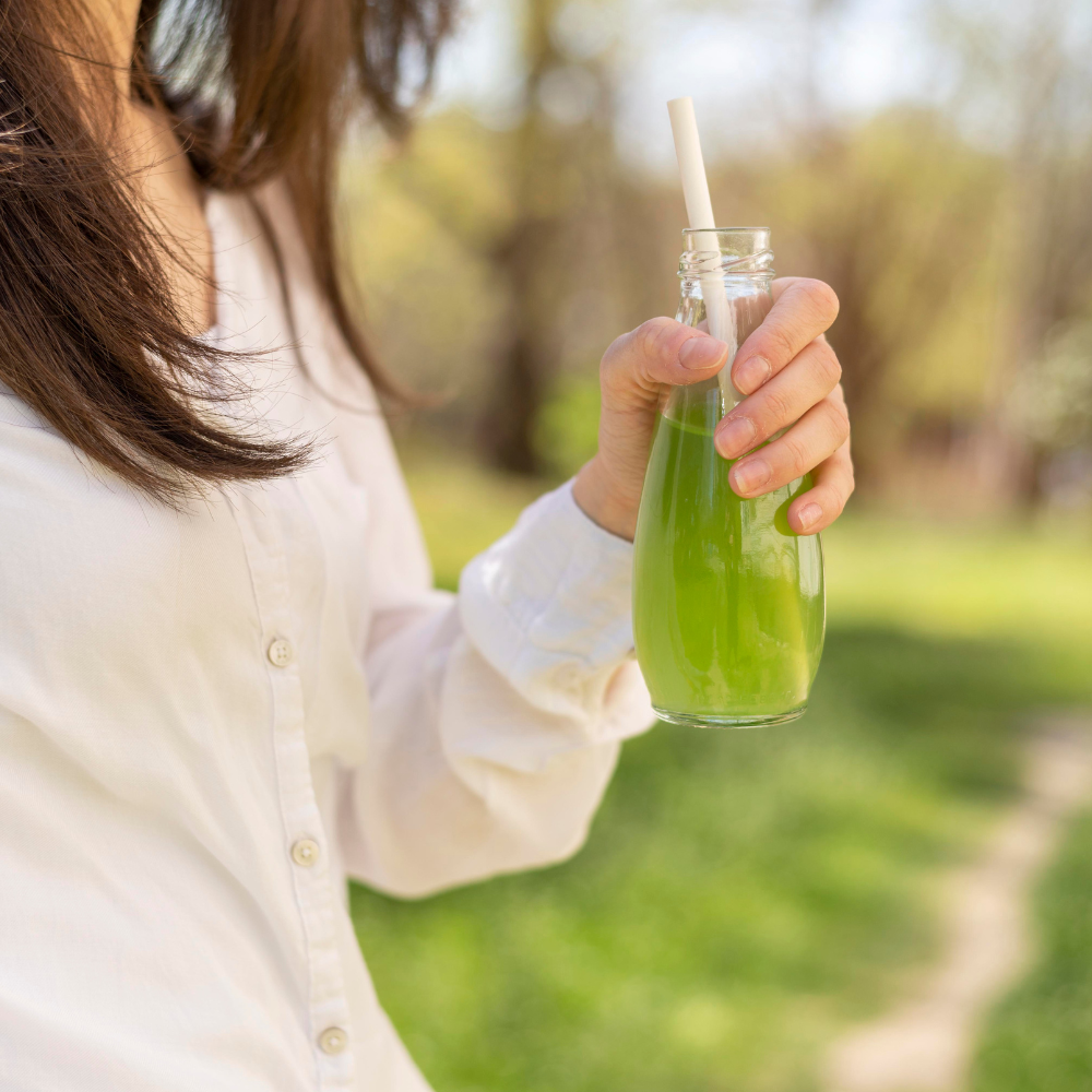 Woman drinking juice from glass bottle