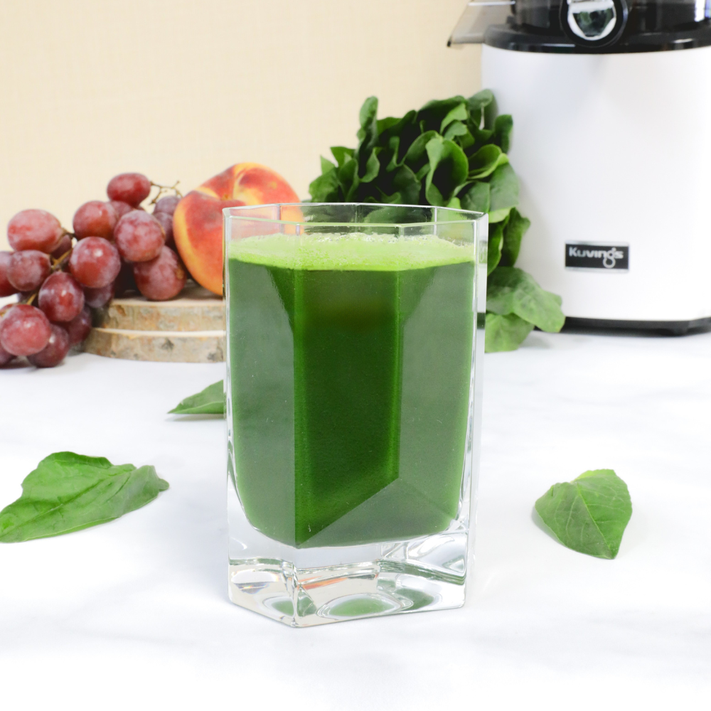 Green juice made of spinach peach apricot and grapes with a Kuvings juicer
