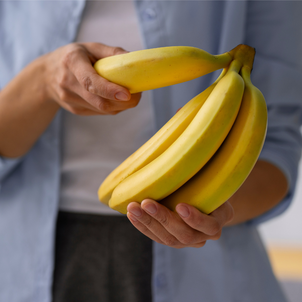 Front view of woman holding a bunch of bananas