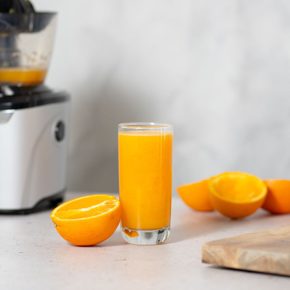 A glass of orange juice made with the Kuvings AUTO10 citrus attachment