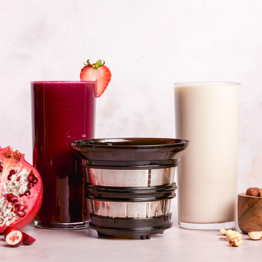 A glass of red juice and a glass of milk next to the AUTO10 juicing strainer