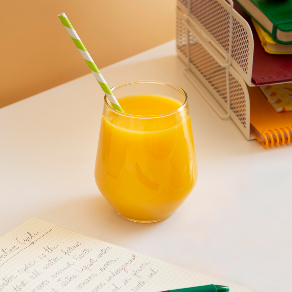 High angle of children's desk with orange juice