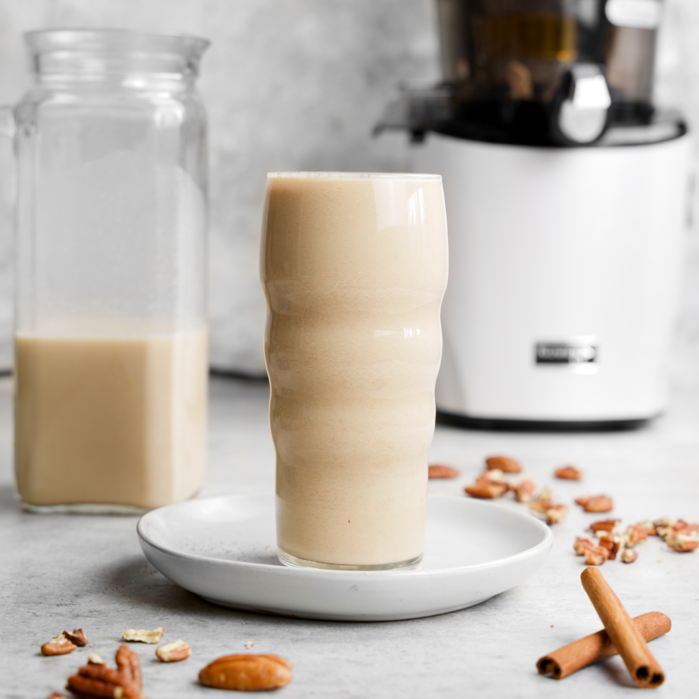 Glass of pecan milk with scattered pecans