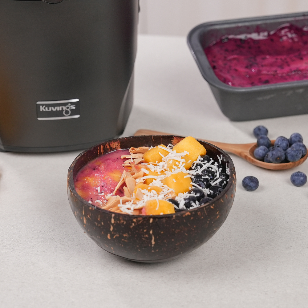 A coconut-looking bowl containing fruit sorbet and toppings