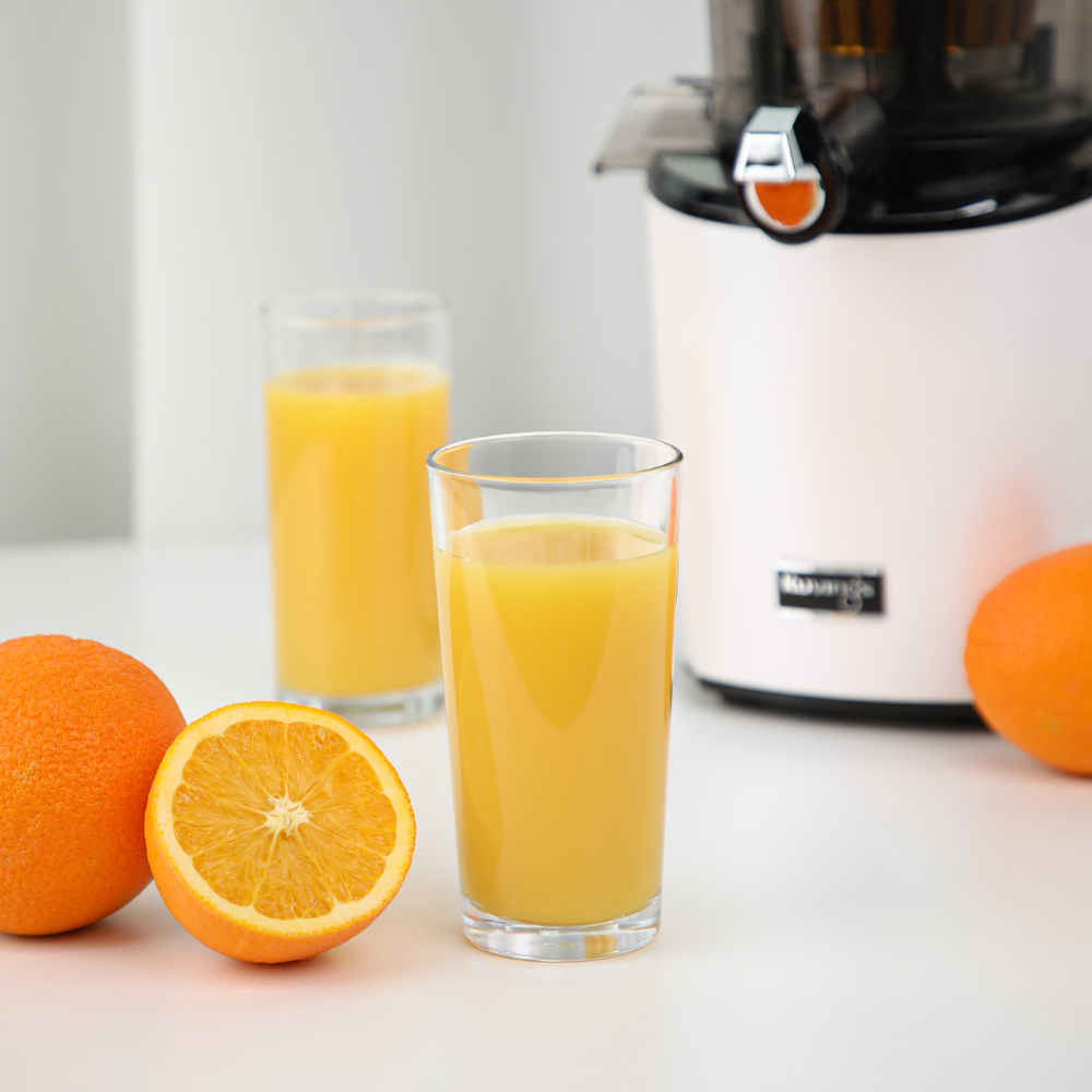 orange juice and oranges in front of a Kuvings REVO830