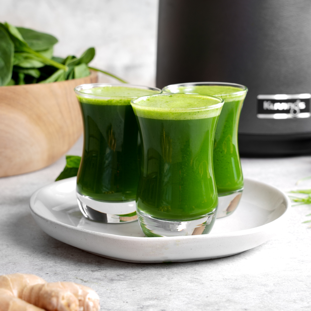 3 green juice shots on a white plate