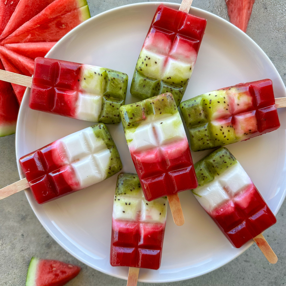 6 watermelon popsicles on a white plate