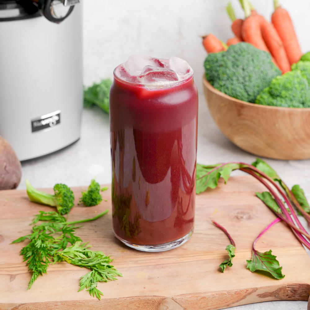 juice made from beet leaves broccoli stems and carrot tops in a glass with ice
